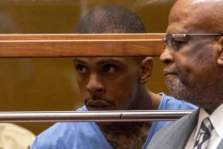 Eric Holder, the murderer of Nipsey Hussle looks through a glass inside a court in LA.